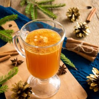 Hot buttered room glass with festive cones and spruce