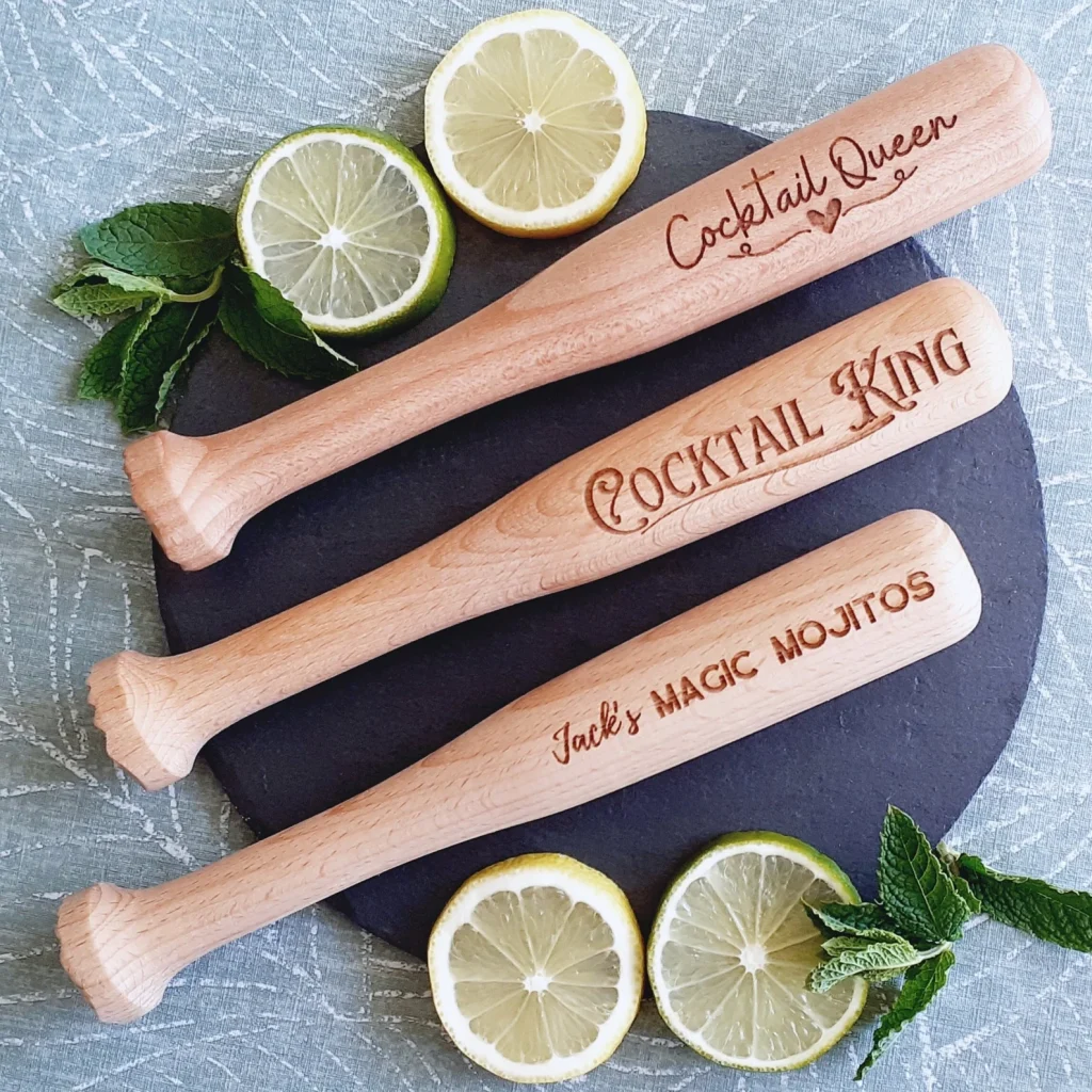 personalized beechwood muddler sticks against a slate plate and limes