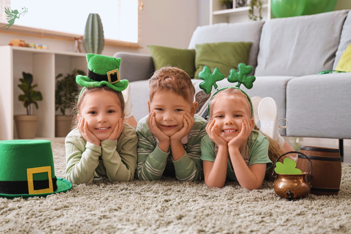3 cute children lying on the floor smiling with st patricks day decorations and pots of gold
