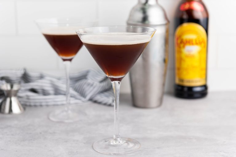 espresso martini glass with Kahlua bottle and shaker in background