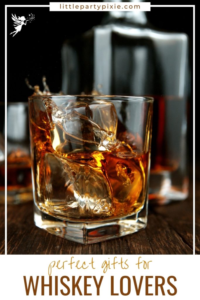Glass of whiskey with ice splashing, bottle blurred in background