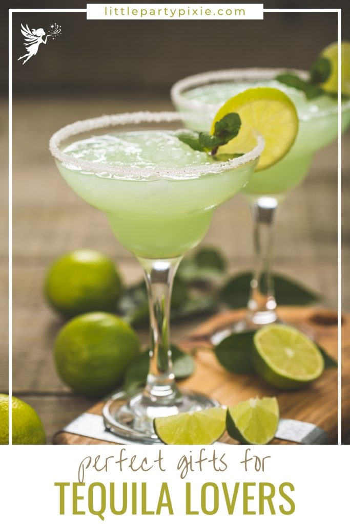 Two margarita glasses with lime slices on a wooden cutting board