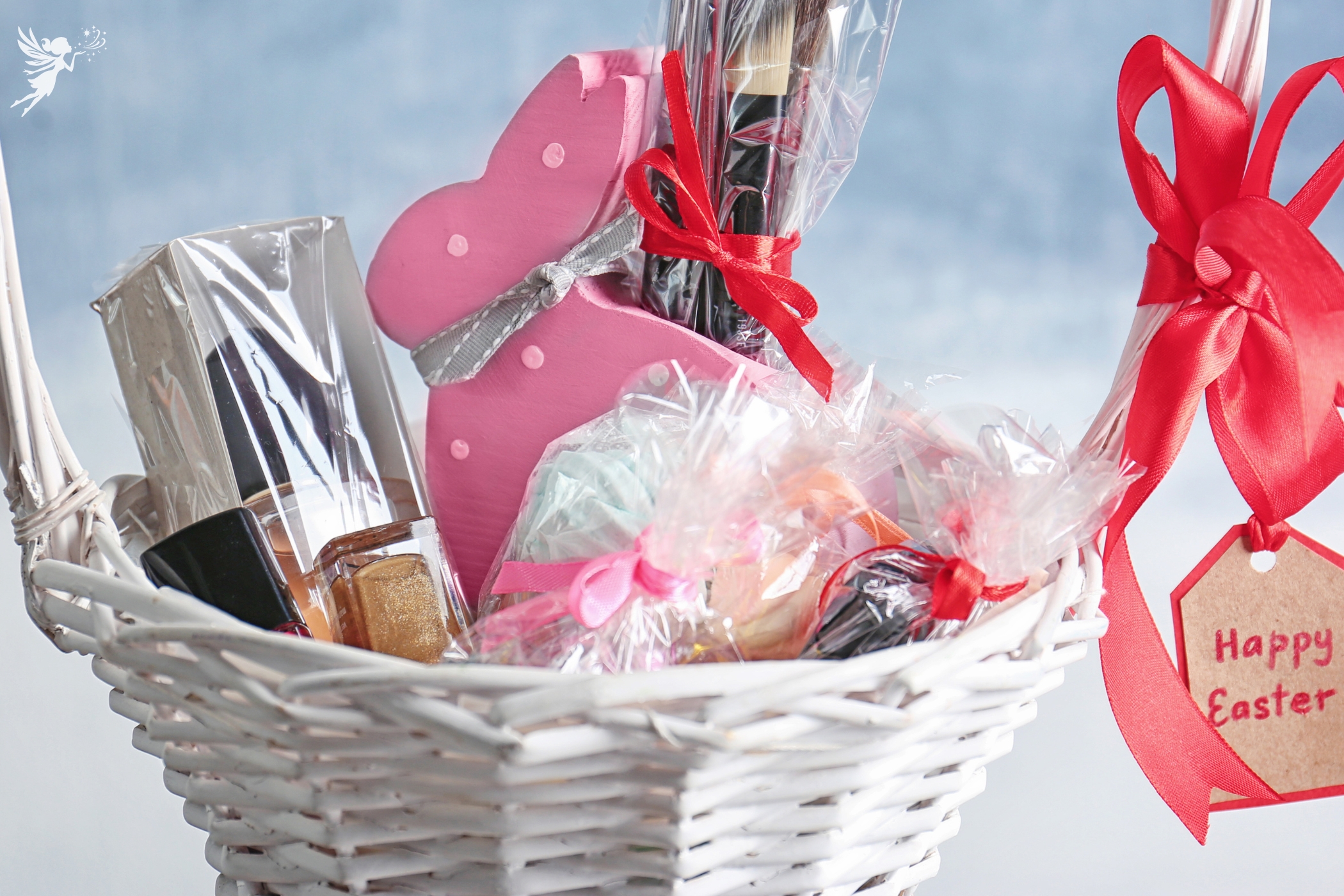 a white basket of cellophane wrapped beauty products with a tag hanging off saying happy easter
