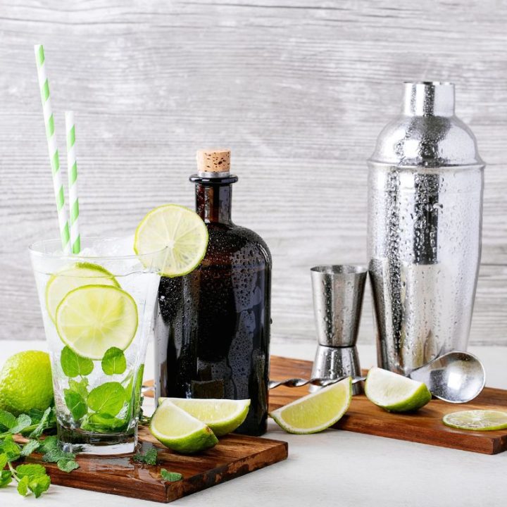 Refreshing mojito with lime, mint, and bar tools displayed beautifully