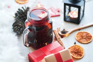 Festive mulled wine in mason jar with dried oranges and gifts