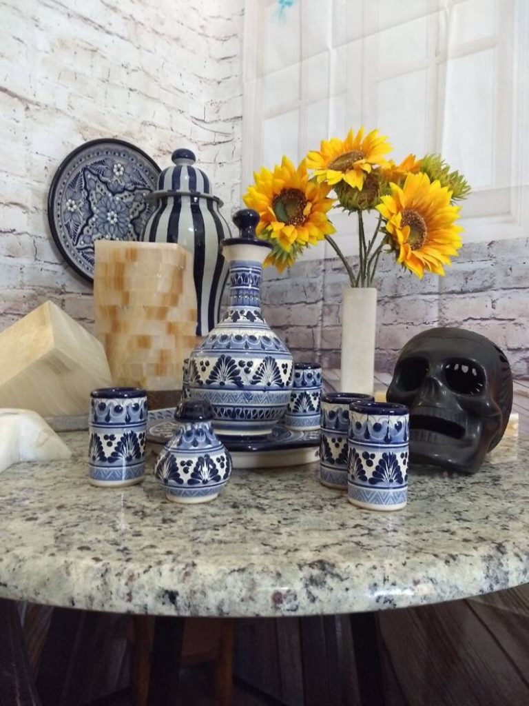 Blue Talavera tequila set on marble table with sunflowers and skull
