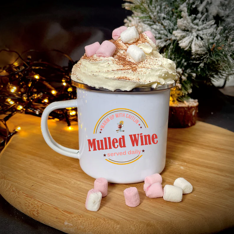 Personalized mulled wine mug topped with whipped cream and pastel marshmallows