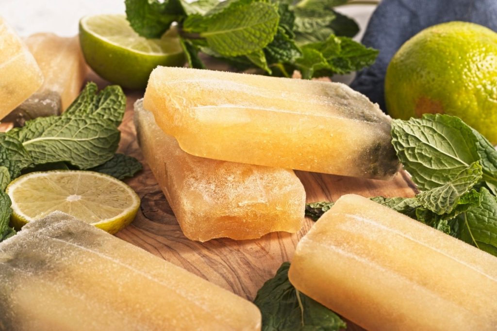 virgin mojito flavored popsicles shown in an artistic display on a wooden tray with mint