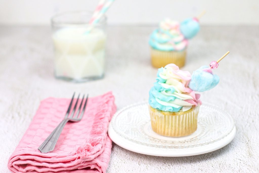 cotton candy cupcake plated with a pink napkin and fork