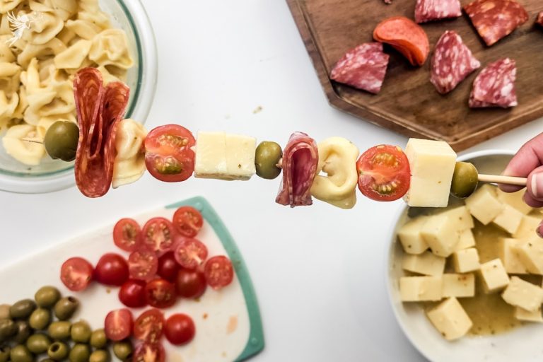 Antipasto skewers with cheese cubes, salami, tortellini, olives, and cherry tomatoes.