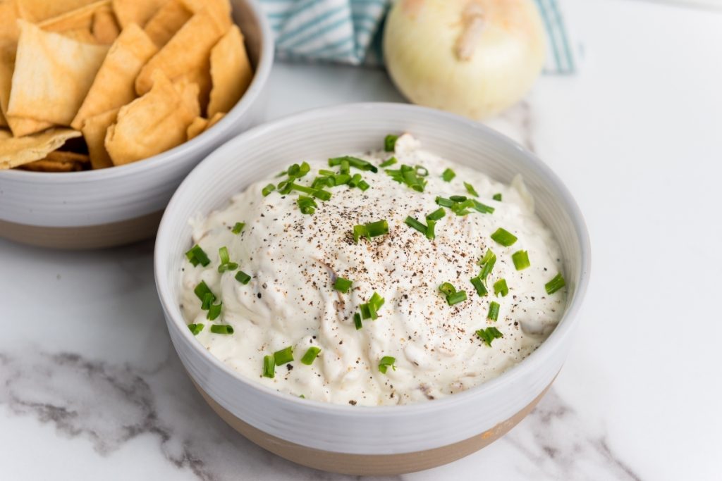Process image for making Caramelized Onion Dip - finished dip garnished with chives and served with chips