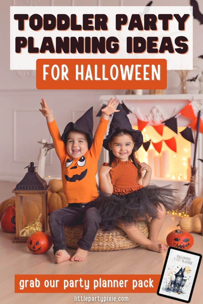 two cute toddler children dressed in orange and black with witches hats in a room decorated in orange and black for a halloween party