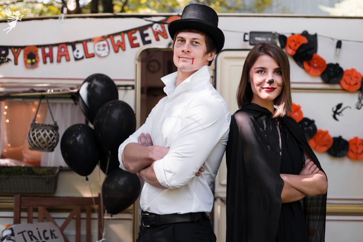 Halloween costume couple in front of a camper with halloween decorations