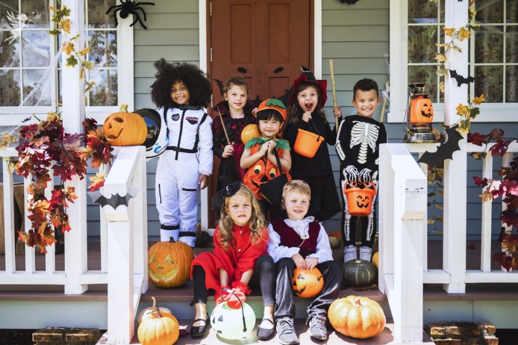 kids on a wooden porch dressed in halloween costumes