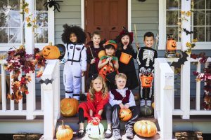 kids on a wooden porch dressed in halloween costumes