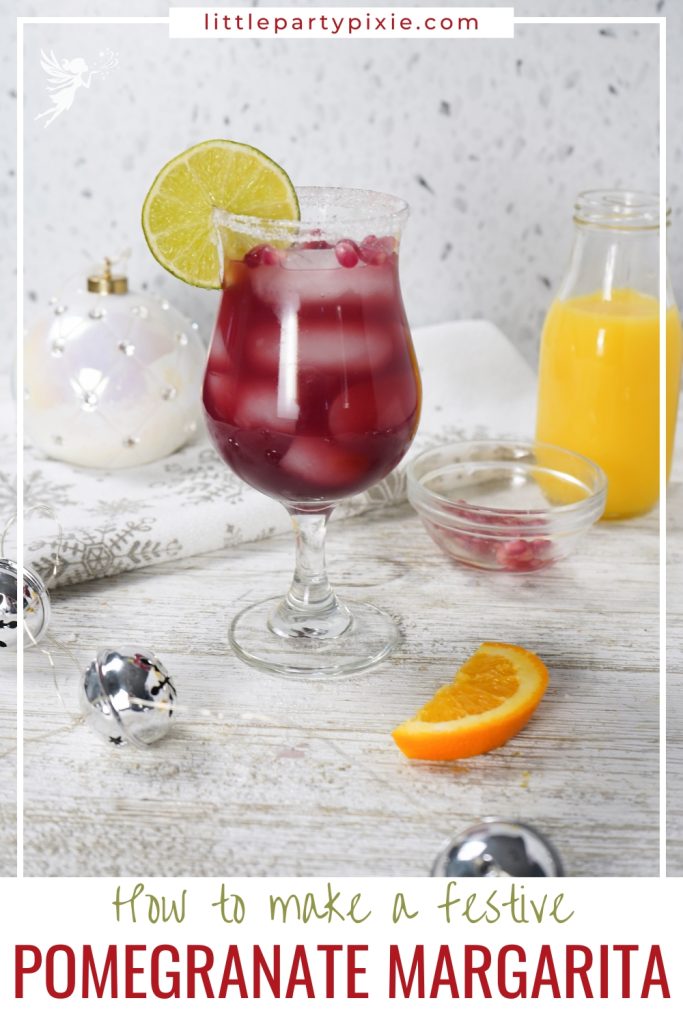 A festive, sugar-rimmed Pomegranate Margarita in a stemmed glass, garnished with a lime slice and pomegranate seeds.