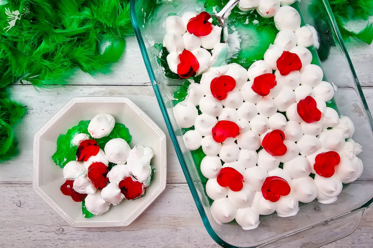 Served Grinch Jello dessert: A bowl and a baking dish filled with green jello, white topping, and red jello hearts.