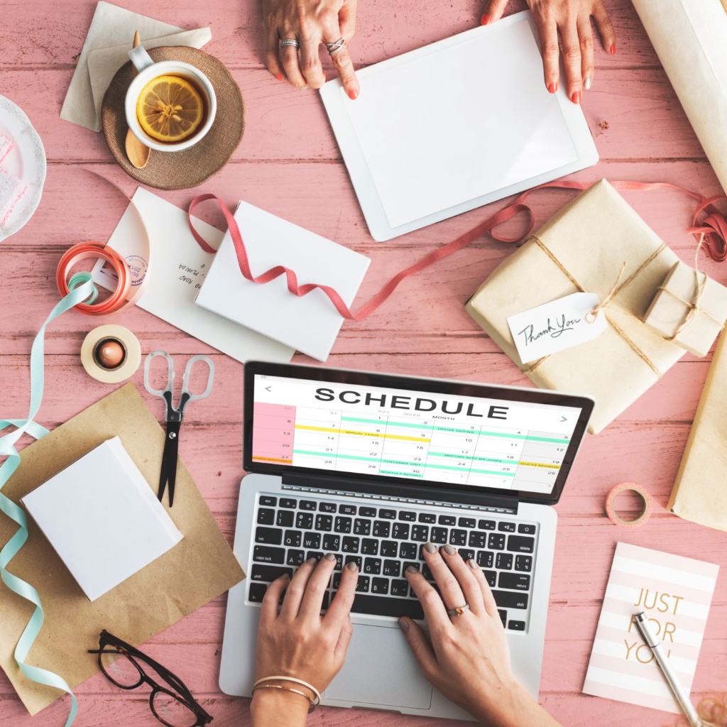 lady working on a computer pink tones flatlay