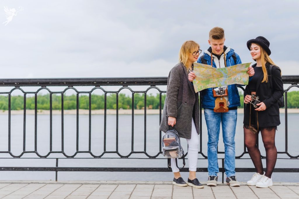 3 tourists looking up a map