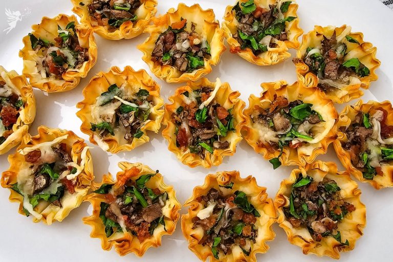 Overhead shot showcasing a serving plate full of savory and vibrant Stuffed Mushroom Phyllo Bites appetizer pastries.