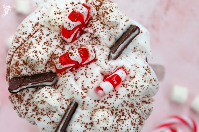 Overhead close-up of the rich whipped cream and chocolate shavings topping the festive Christmas Peppermint Hot Chocolate.