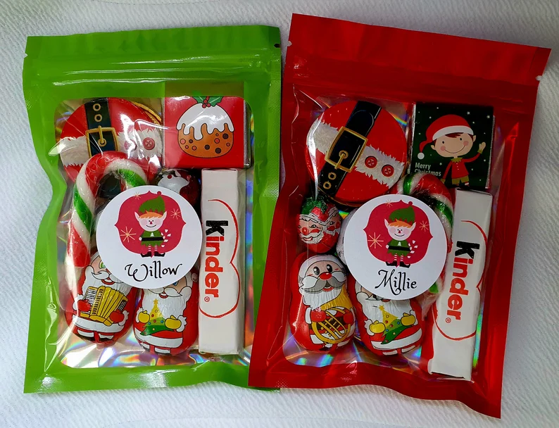 Personalized Christmas sweet pouches with Kinder bars and holiday chocolates, a tasty addition to Christmas Eve Boxes.