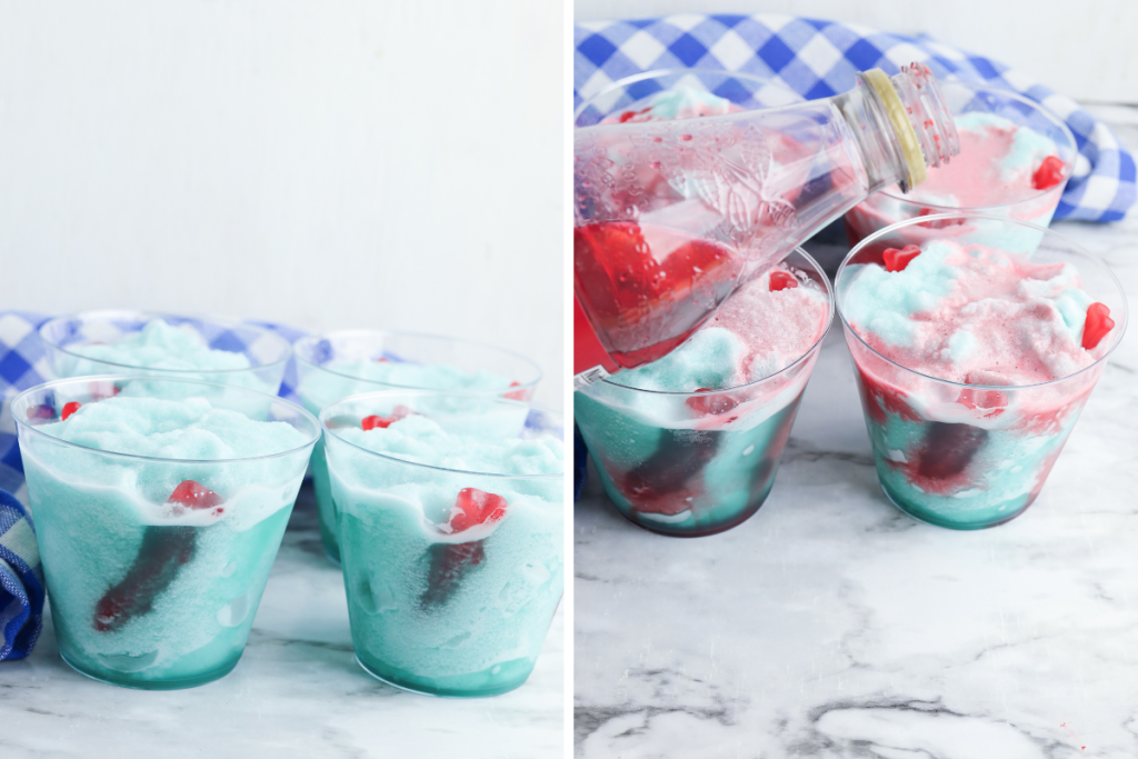 Pouring red syrup "blood" over the blue Shark Attack Slush in clear glasses, adding to the dramatic presentation.