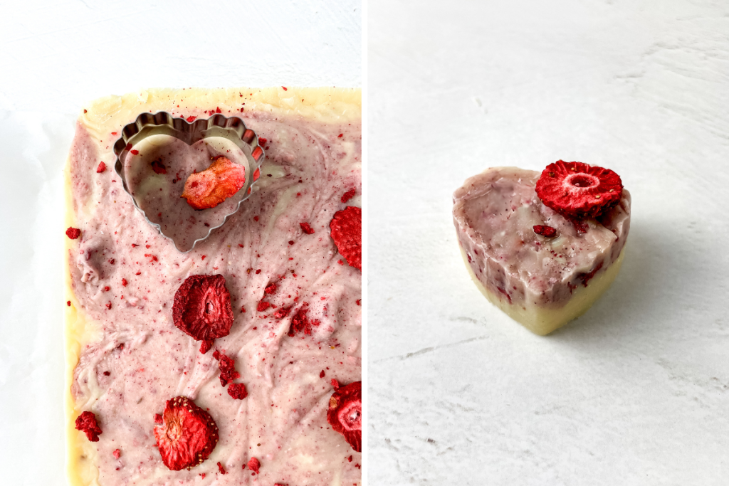 A heart-shaped cutter is used on the chilled, marbled pink and white fudge, creating individual pieces of finished Strawberry Cream Fudge topped with a dried berry.