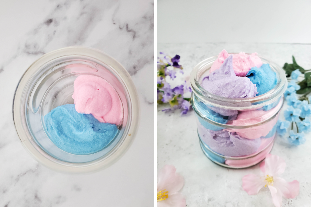 Layers of pink, blue, and purple scrub are swirled together in a clear jar, presenting the finished colorful and fragrant Whipped Rainbow Sugar Scrub.