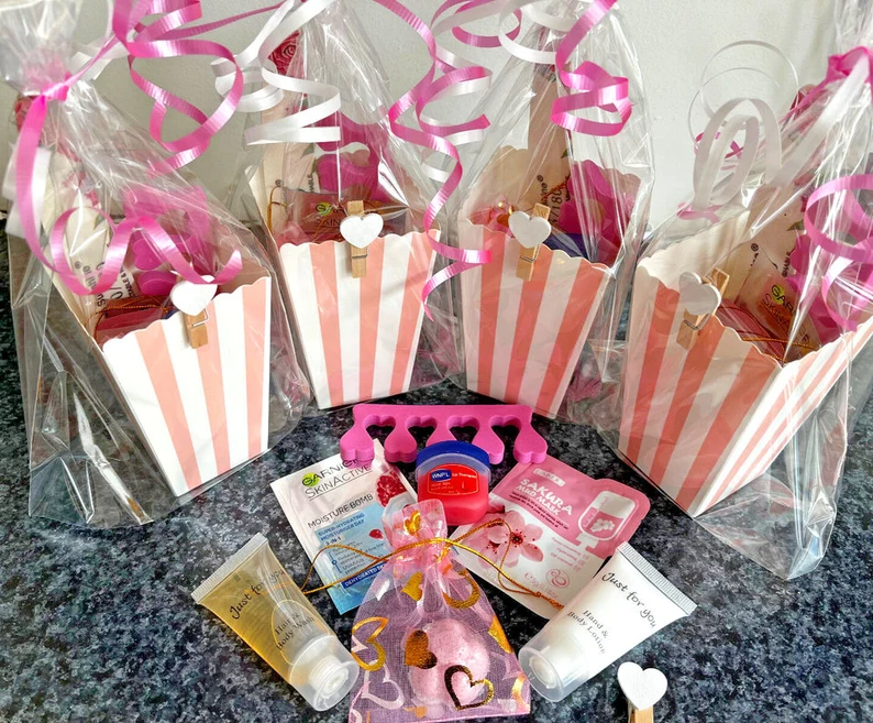 Four pink and white striped popcorn boxes wrapped in cellophane, filled with spa and beauty products, great Teen Party Favors. Etsy