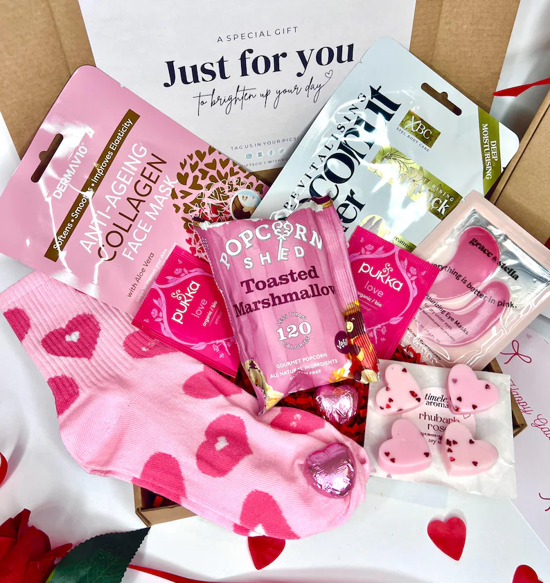 Fun Galentine's Day Gift box/Party Favors with anti-aging face masks, heart socks, gourmet popcorn, tea bags, and heart-shaped wax melts.