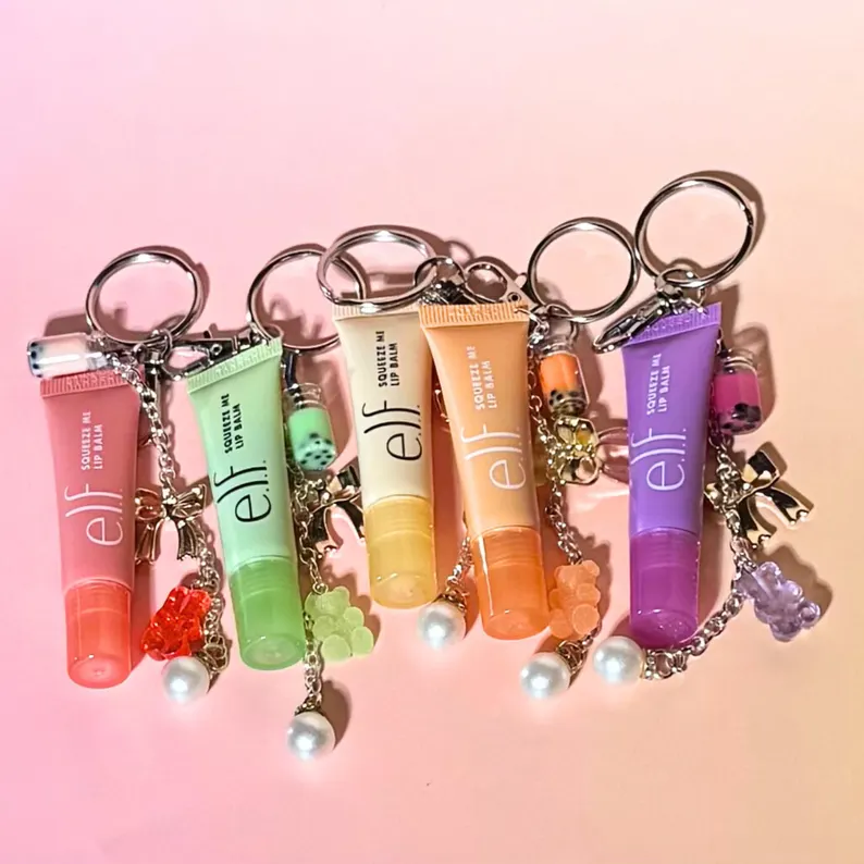 Five colorful e.l.f. lip balm tubes attached to keychains, decorated with gummy bear charms, excellent Teen Party Favors. Etsy