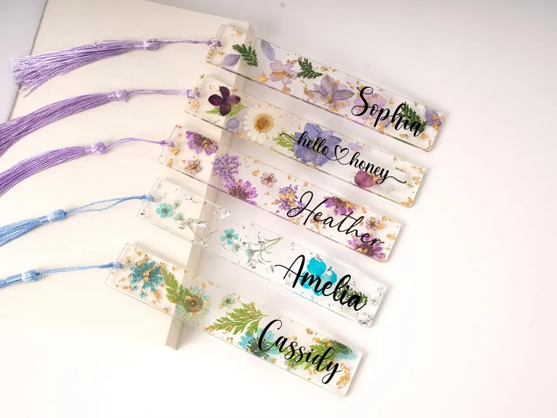 Handmade resin bookmarks with pressed flowers and gold flakes, a beautiful option for book-loving birth month gifts.