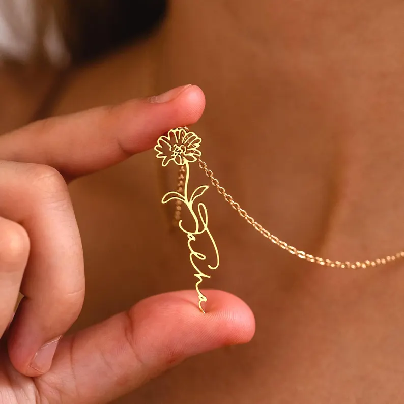 Customized name necklace featuring a delicate floral outline in gold, offering a thoughtful and elegant choice for birth month gifts.