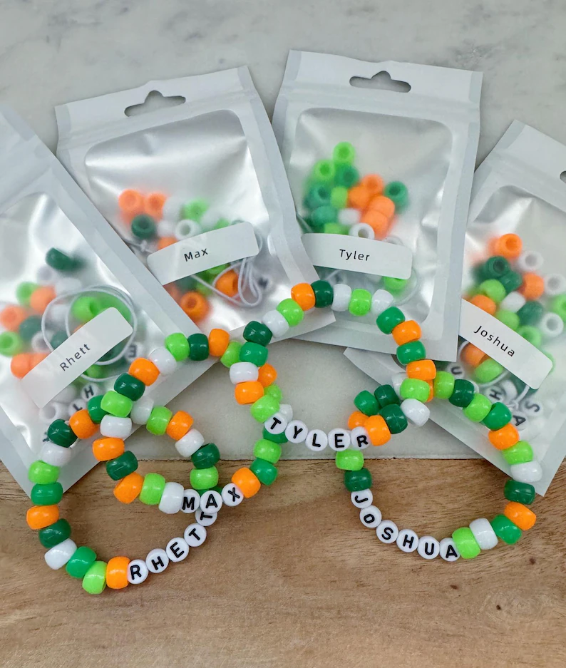 Personalized DIY bead bracelet kits with name labels and green and orange beads, perfect as St. Patrick's Day favors.