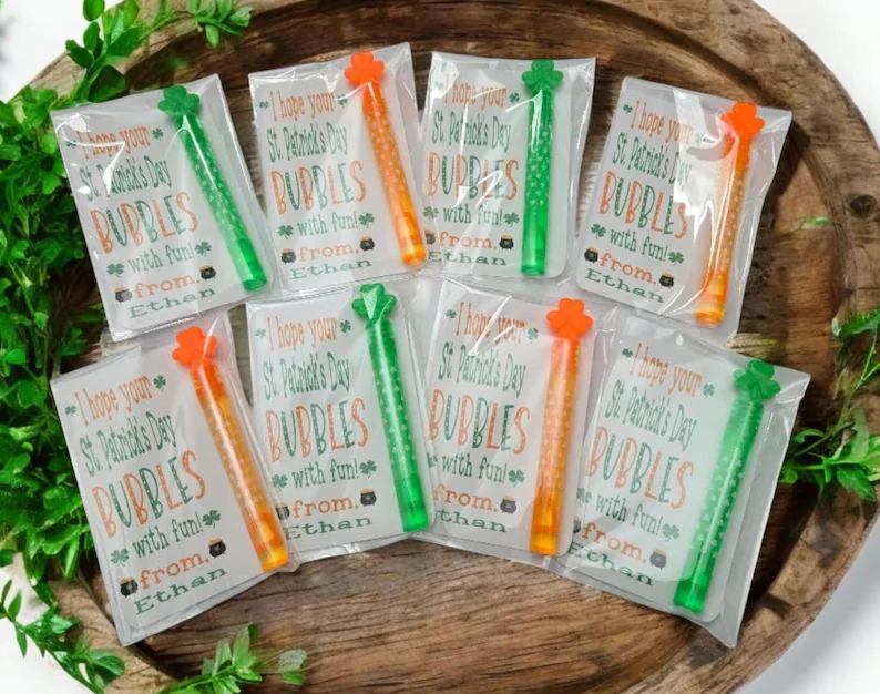 Green and orange bubble wands attached to personalized gift cards, ideal for outdoor-themed St. Patrick's Day favors.