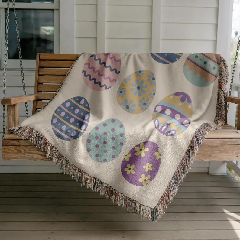 Woven fringe blanket featuring colorful patterned Easter eggs on a porch swing, perfect as an Easter hostess gift.