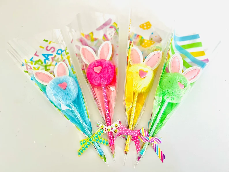 Vibrant fluffy pom-pom pens with bunny ears and heart details, individually wrapped in festive cellophane for easy Easter Party Favors Kids gifts.