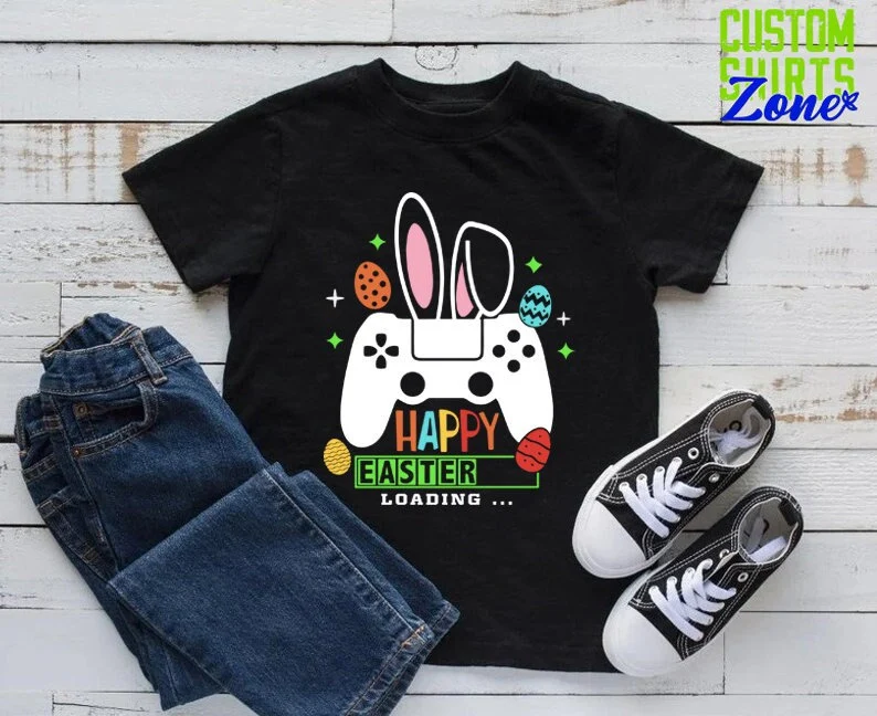 A black t-shirt featuring a gamer controller with bunny ears, titled "Happy Easter Loading," perfect as an Easter basket filler for boys.
