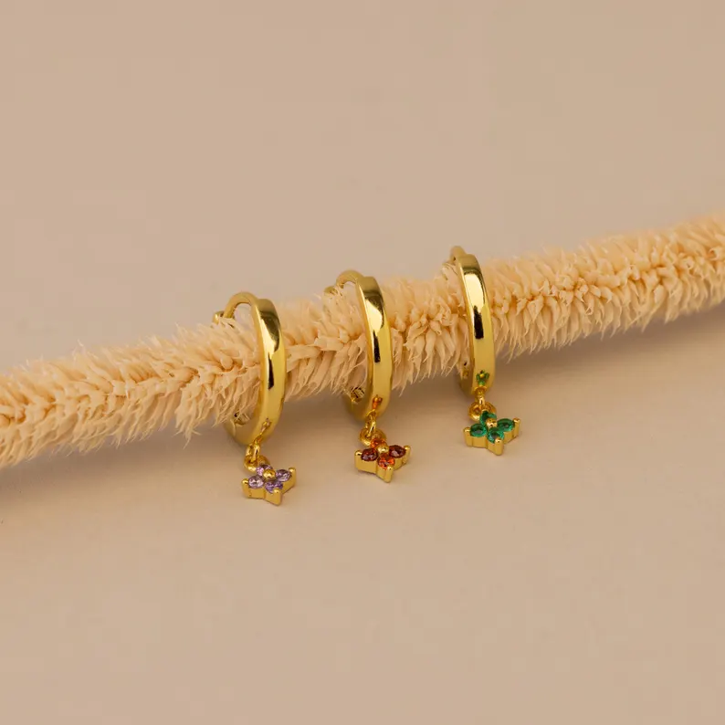 Gold hoop earrings featuring flower-shaped birthstone charms, making them elegant and personalized birth month gifts for women who love floral jewelry.