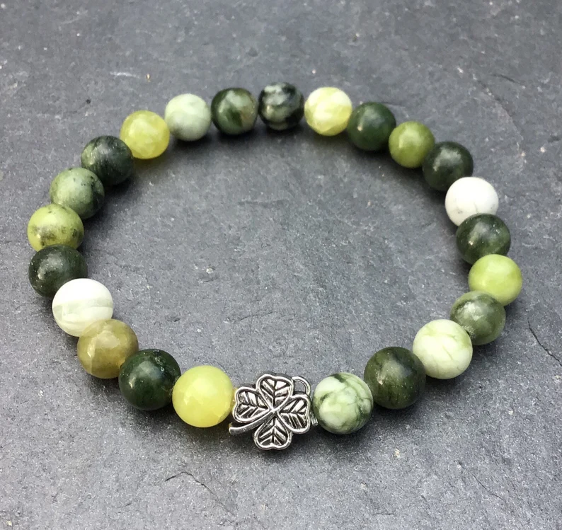 A beaded stretch bracelet with green marble stones and a silver clover charm, designed as stylish St. Patrick's Day favors.