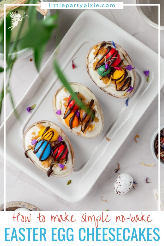 Overhead view of three Easter egg cheesecakes arranged on a rectangular plate, showcasing a festive and simple no-bake holiday dessert.