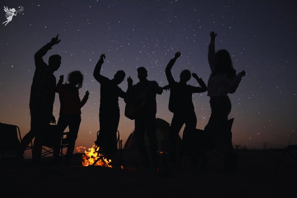 teens dancing in silhoutte with a bonfire