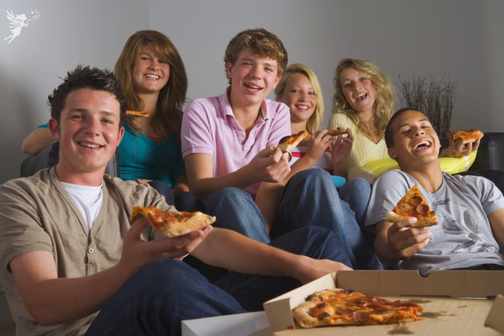 teen boys and girls eating pizza