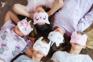 tween girls lying on bed with sleep masks