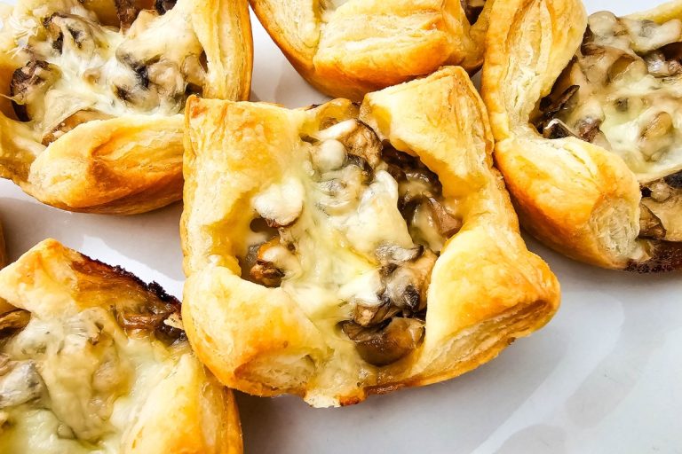 Close-up of flaky Mushroom Puff Pastry Bites filled with melted cheese and sautéed fungi, a delicious vegetarian party snack.