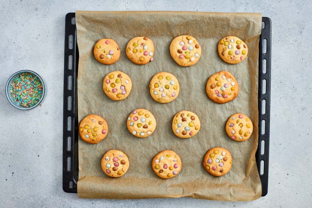 Freshly baked golden brown treats on a baking sheet, showcasing the perfect texture for a chewy Easter cookie recipe.