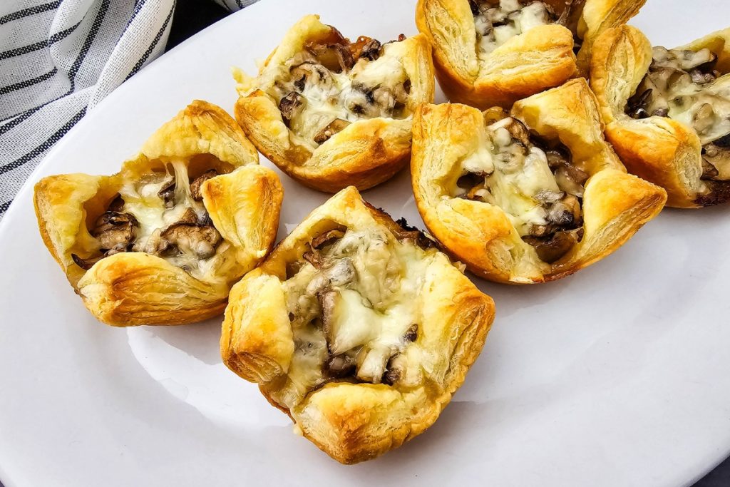 Freshly baked Mushroom Puff Pastry Bites with melted cheese, a perfect savory pastry snack for entertaining guests at home.