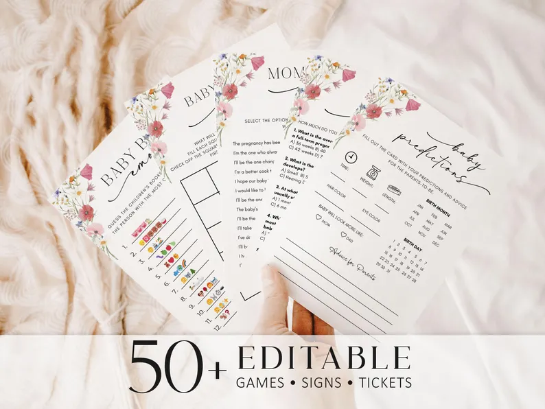A hand holding a fan of wildflower-themed printable baby shower game cards including emoji and prediction activities, versatile baby shower gifts and entertainment for guests.