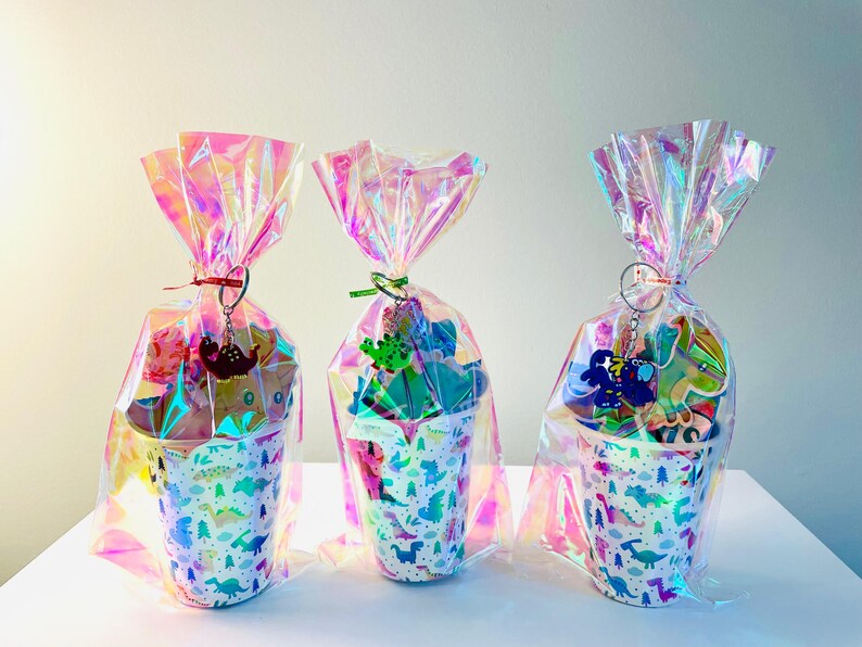 plastic dino party cups wrapped in cellophane and filled with dinosaur related party treats for kids etsy